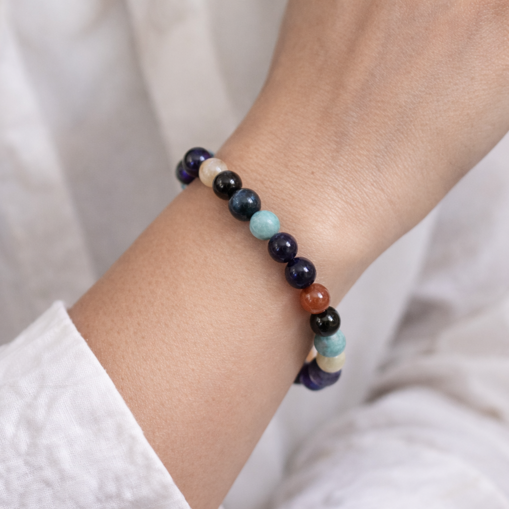 Multicolored beaded bracelet on a wrist with a neutral background