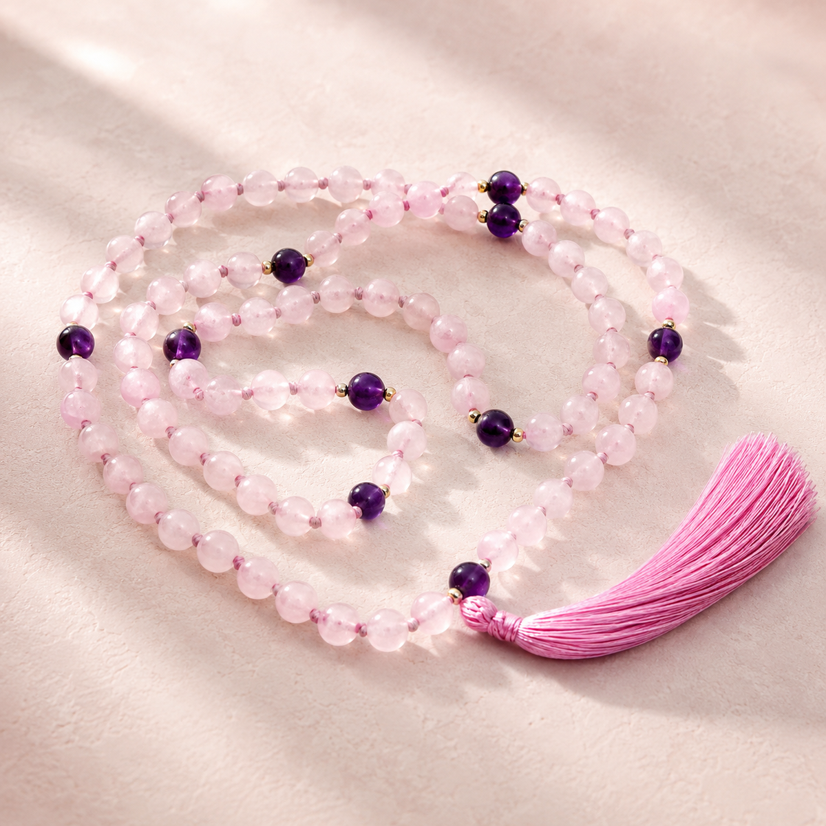 Necklace with pink beads and purple accents on a light background